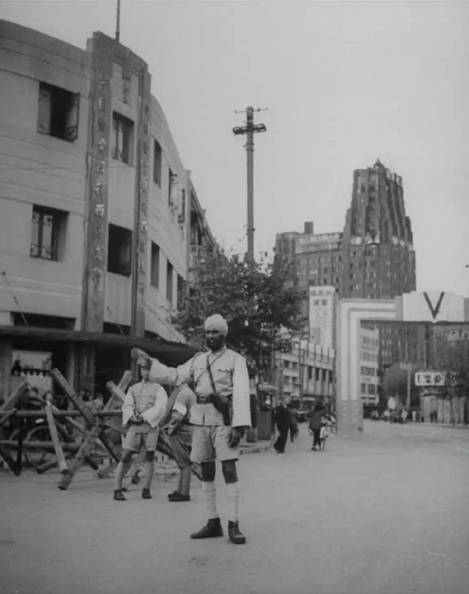 1945年，上海街头，一名指挥交通的印度警察，打着绑腿，头上包着方巾，看起来神气