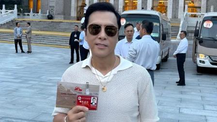 阅兵观礼台上，甄子丹以素色衣衫现身，毫无明星架子。他11岁随父母赴美，2009年