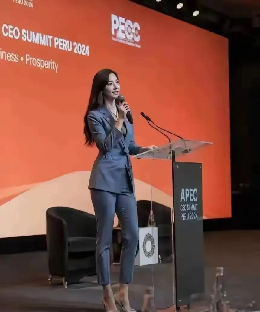 一位女士在台上演讲，职业装让美女更有气质！