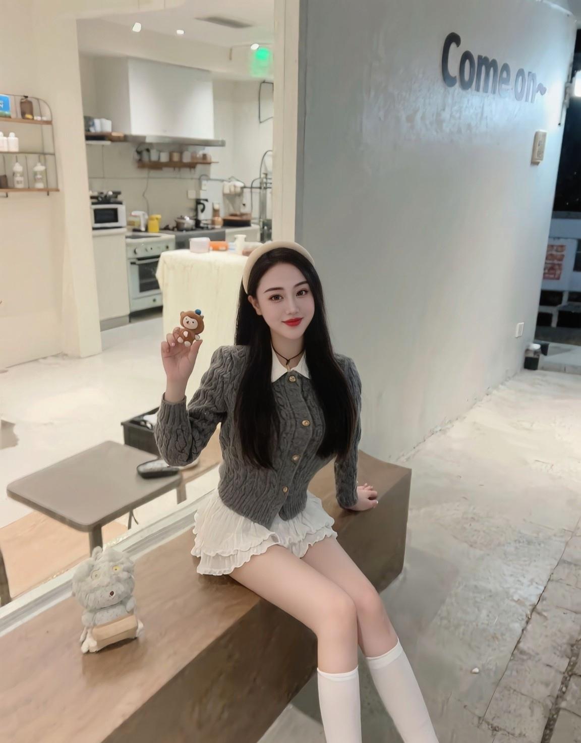 在咖啡馆里，小姐姐展示着可爱的毛绒玩具。