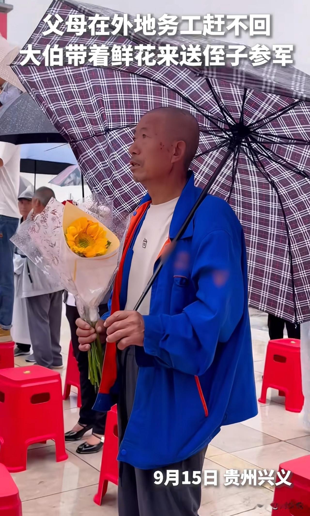 “泪目！”贵州兴义，新兵出发现场，一位大伯打着雨伞，穿着雨衣，手拿一束鲜花，在人