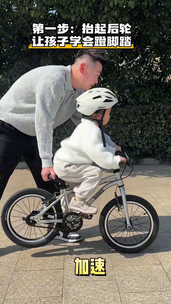 让孩子学会蹬脚踏。
爸爸教三岁女儿学自行车，这方法几分钟就学会了。
·第一步：抬