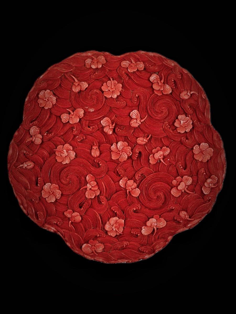 清代· 剔红落花流水梅英纹梅花式盒。帘外雨潺潺，春意阑珊，罗衾不耐五更寒
梦里不知身是客，一晌贪欢
独自莫凭栏，无限江山，别时容易见时难
流水落花春去也，天上人间
——五代十国· 李煜《浪淘沙令·帘外雨潺潺》 
清乾隆，乾隆款剔红落花流水梅英纹梅花式盒，故宫博物院藏 
此盒作梅花形，外髹红漆，雕落花流水纹，水波如丝，梅花朵朵散于流水之上，繁而不乱 
内髹黑漆，盒底阴刻”大清乾隆年制”款填金，盒盖阴刻“梅英宝盒”款填金 
这种不刻锦纹，以纹饰遍布全身的装饰手法，是清代乾隆时期宫廷雕漆风格 
古人对“落花流水”