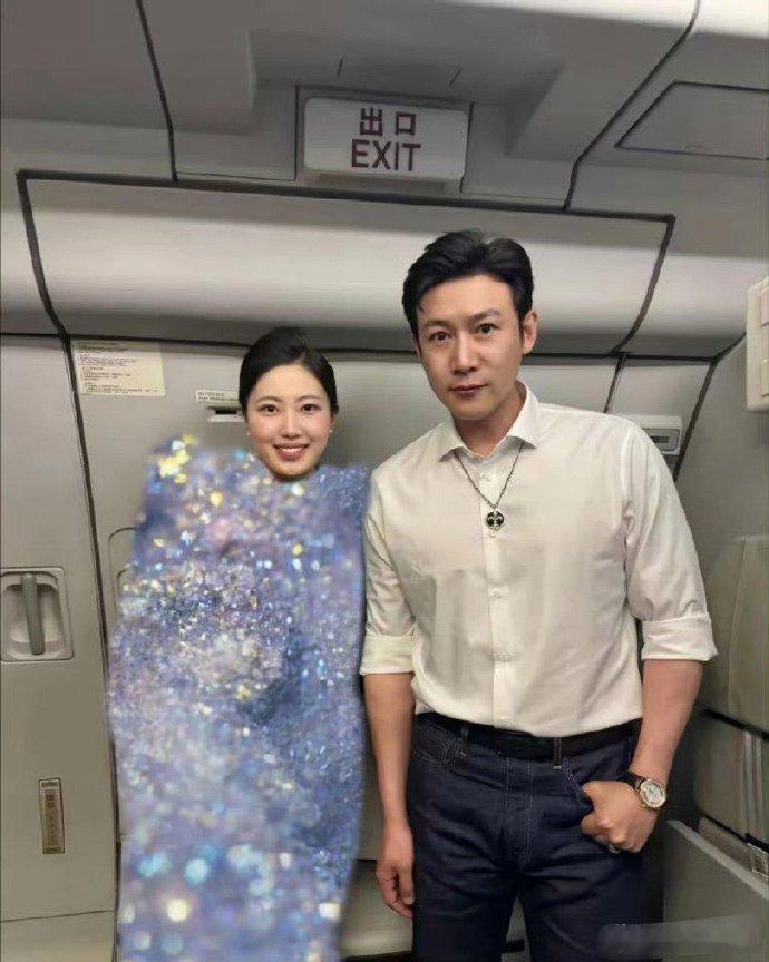空姐与陆毅合影，但空姐衣服上的马赛克处理似乎过于夸张。 ​​​