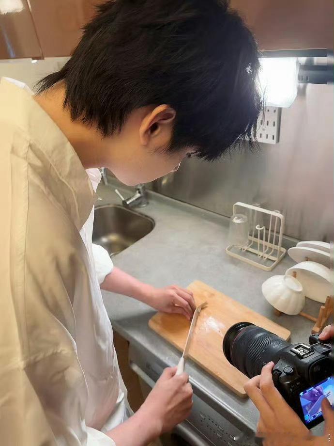 【往年今日】小伞厨房生活照回顾。选手身着白色衬衫进行切菜等烹饪操作，镜头记录其非