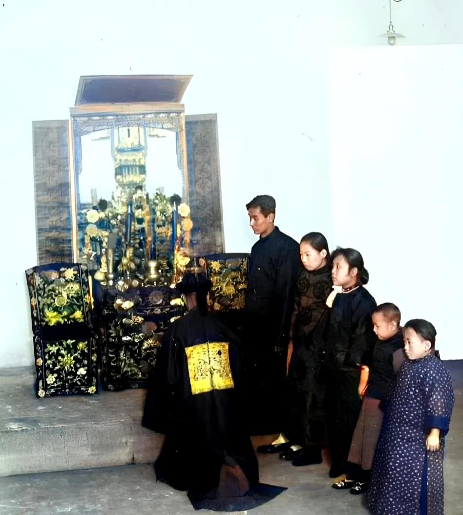 1915年，北京，身穿满清官服的旗人，恭敬地站在案前，插香祭拜。供桌上摆满了香烛