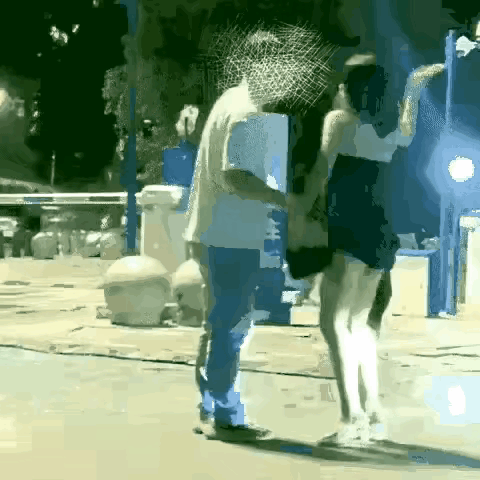 大街上，灯火通明，看到一女子，穿着超短裙，打扮的也很洋气，只见她不停的扇男子的脸