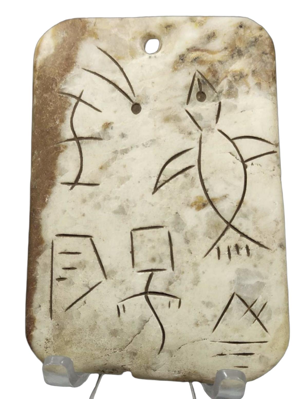 这一块圆角穿孔玉牌，属于上古史前图画文字玉饰，一面以阴刻线条，绘有神鸟、双鱼象形