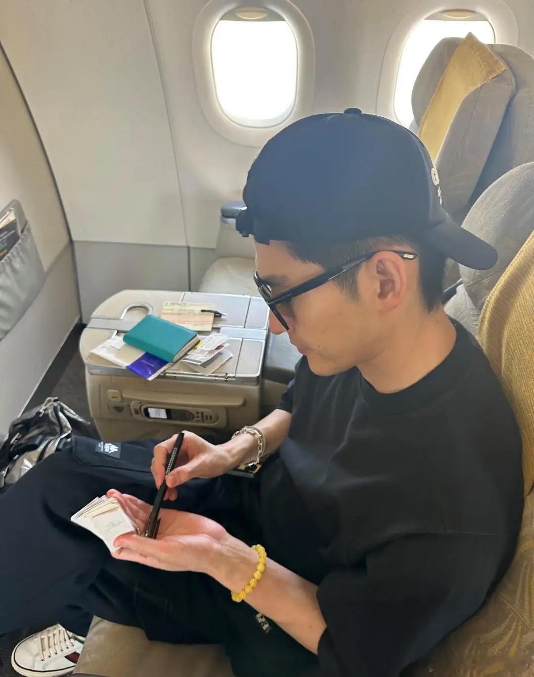 42岁张翰现身机场乘坐飞机商务舱出国被偶遇，他的穿衣打扮很时尚，，他黑衣黑帽黑墨