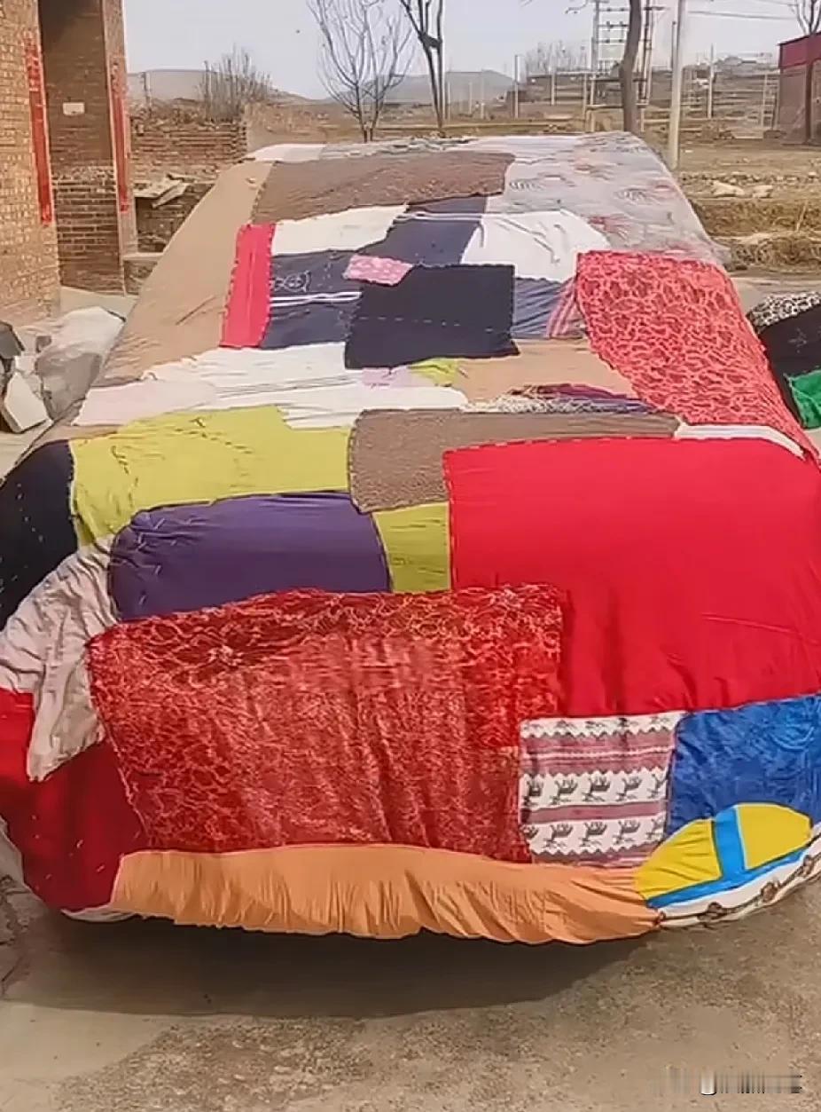 孙子节假日回家，奶奶用废旧衣服给他的爱车缝了一件特别的车衣，这是用各种废布和旧衣