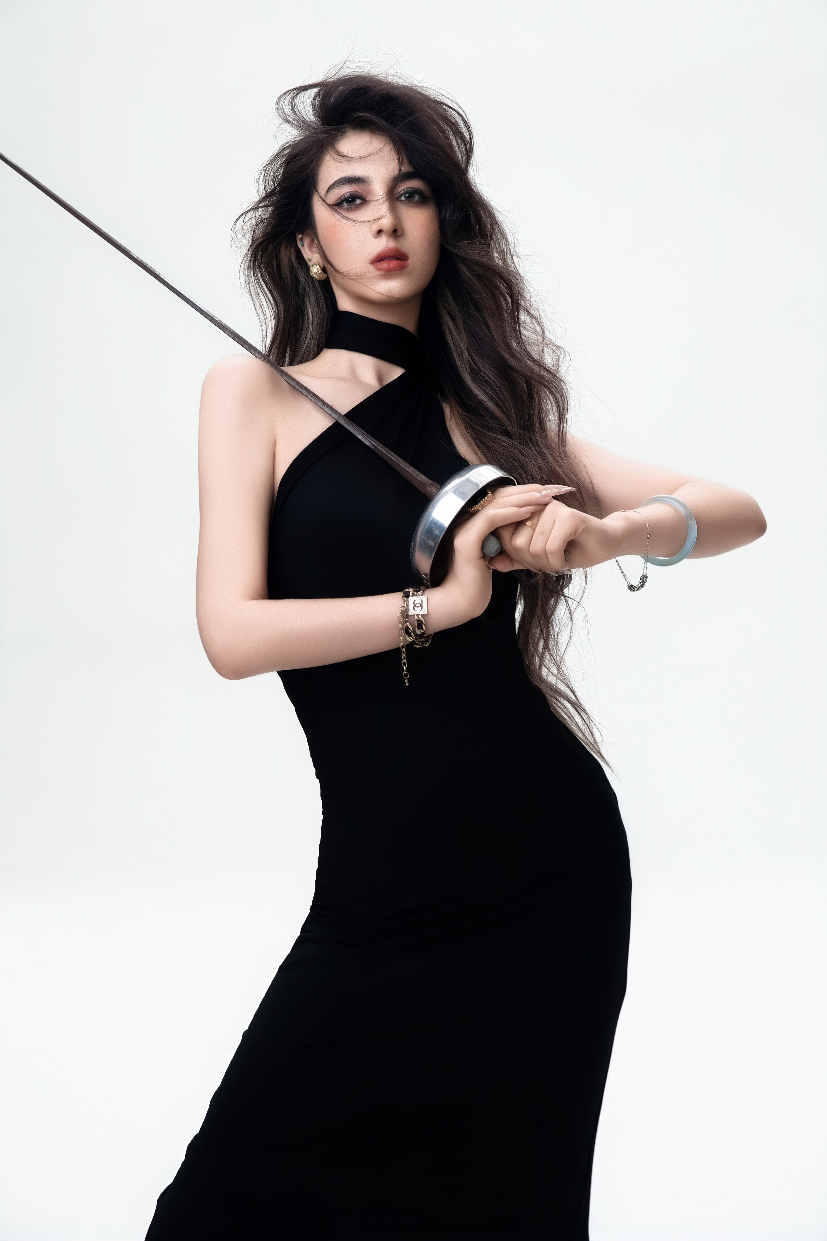 一袭黑裙勾勒曼妙身姿手握长剑🗡️立于聚光灯下目光如炬，如酷飒的女战士剑锋所向之