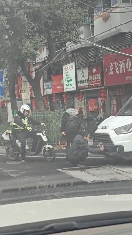 大哥蹲在地上遮挡车牌，结果被交警抓了个正着，你猜他站起来后说了什么[捂脸]