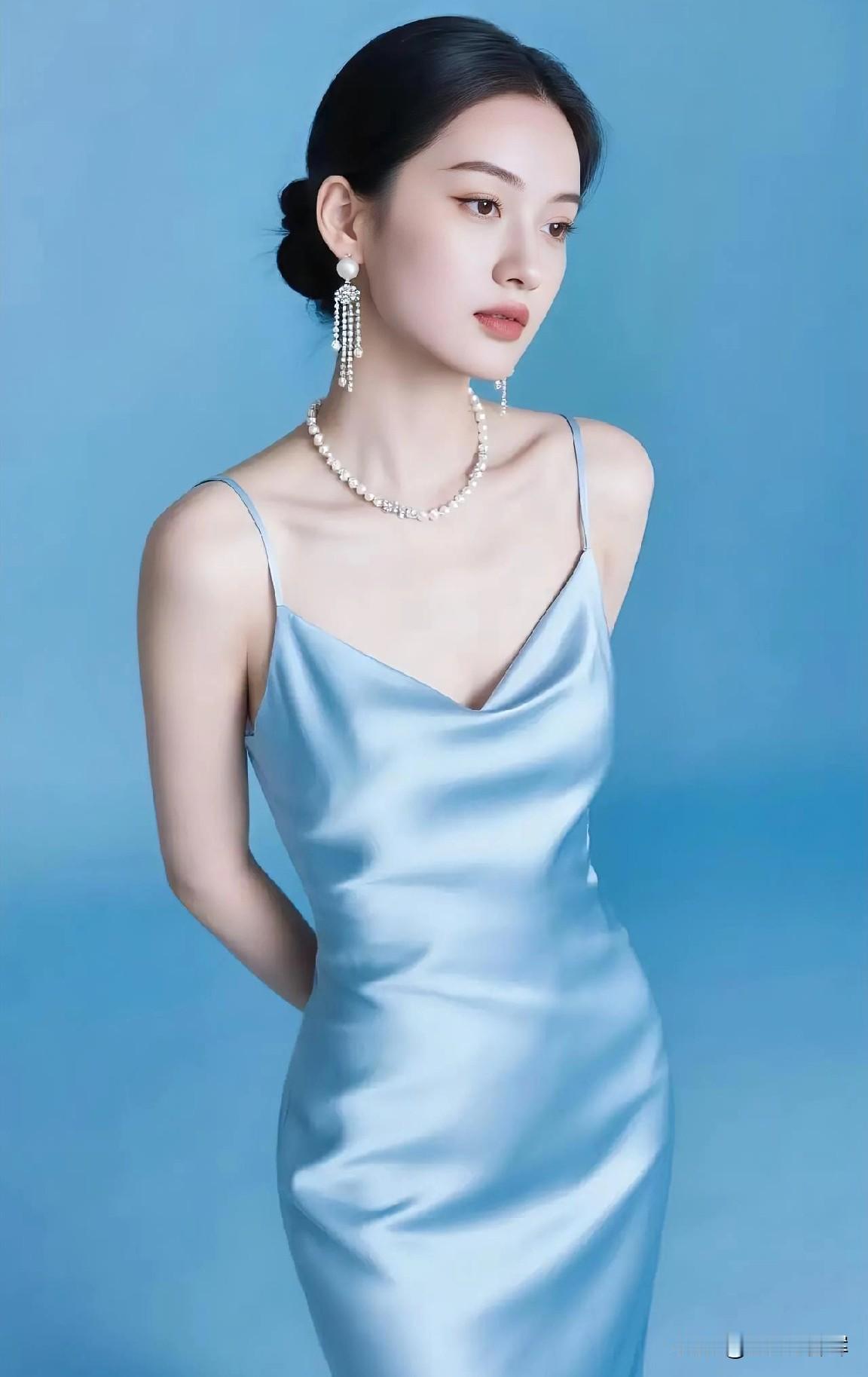 蓝幕如镜，映她身影。

丝缎垂落，漾柔波轻晃。

珍珠垂耳，缀流光细芒。

颈间
