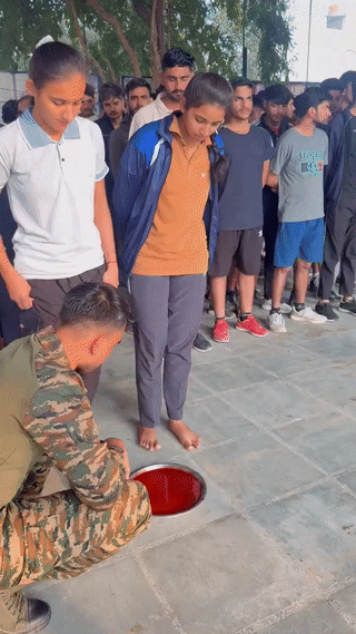 这是印度征兵现场。
应征者，无论男女都需要光脚踩在红色颜料上？
通过脚印的深浅来