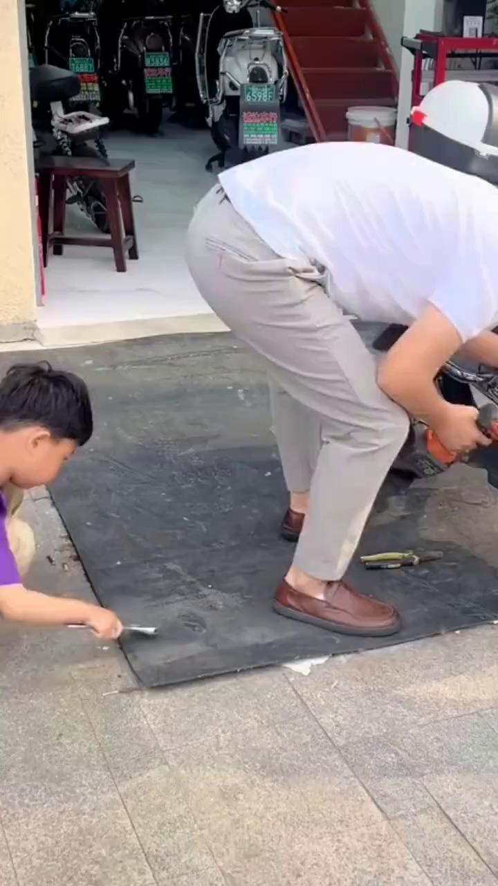 修理摩托车的父子专注在每一个细节。