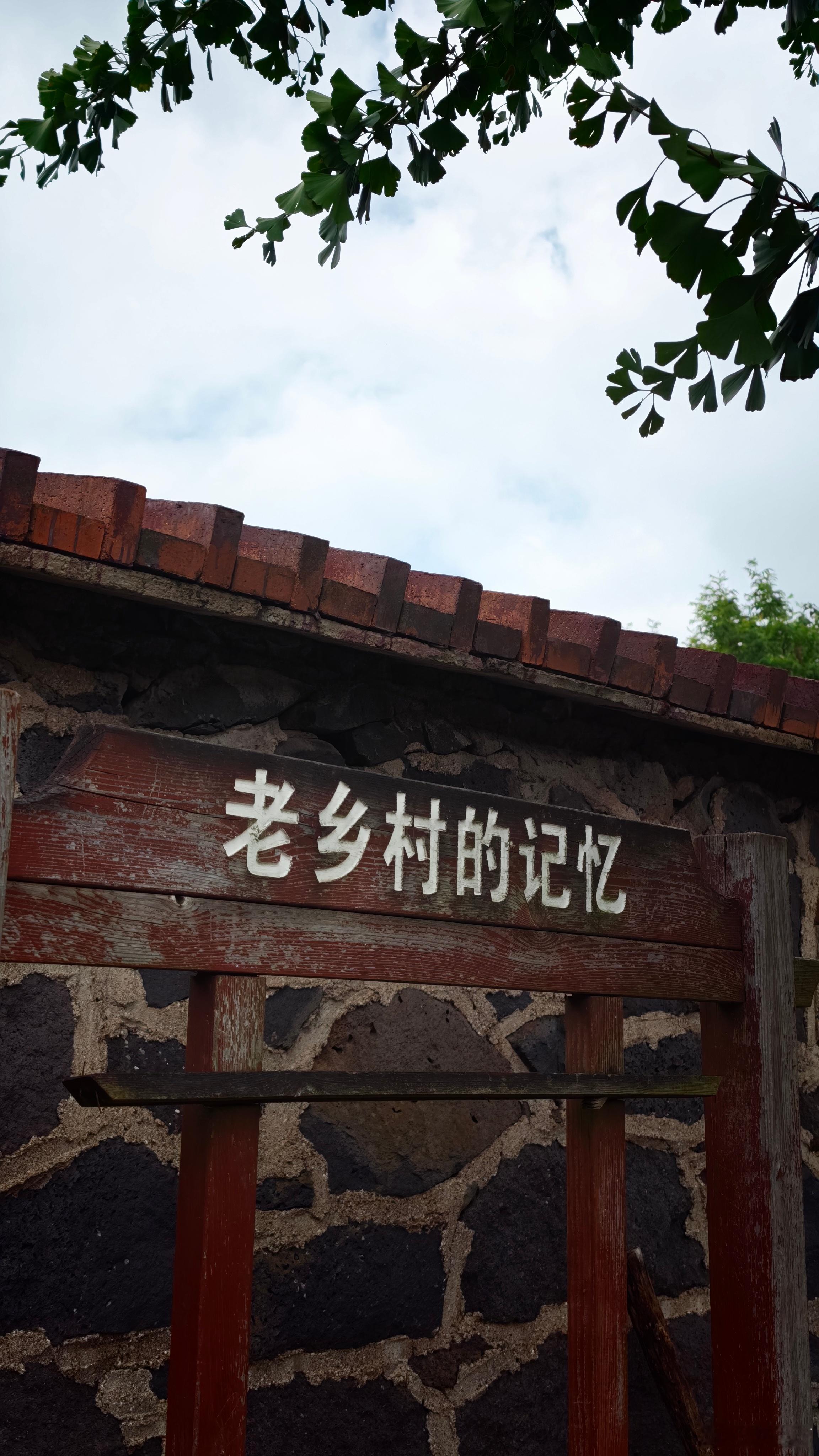 那些关于夏天、关于蝉鸣、关于炊烟的记忆，似乎都刻在了这斑驳的石墙和木牌上。 