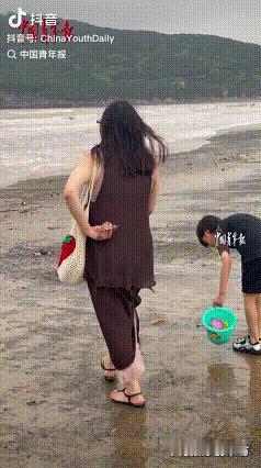 “有妈的孩子像个宝！”浙江舟山，一位妈妈趁着孩子不注意，悄悄把贝壳撒在沙滩上，本