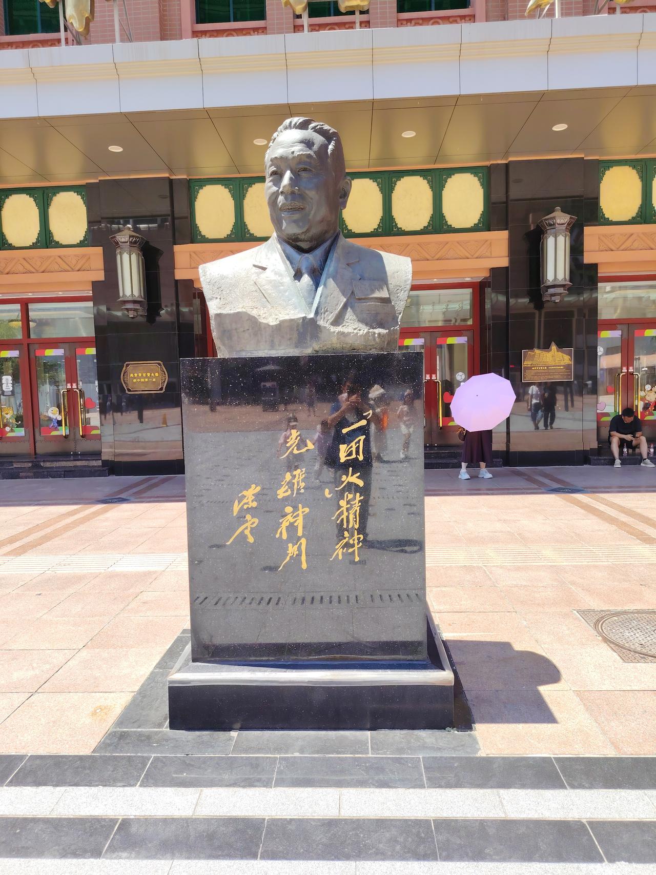这是谁？
塑像立在哪里？
谁题的词？
题词的内容是什么？
