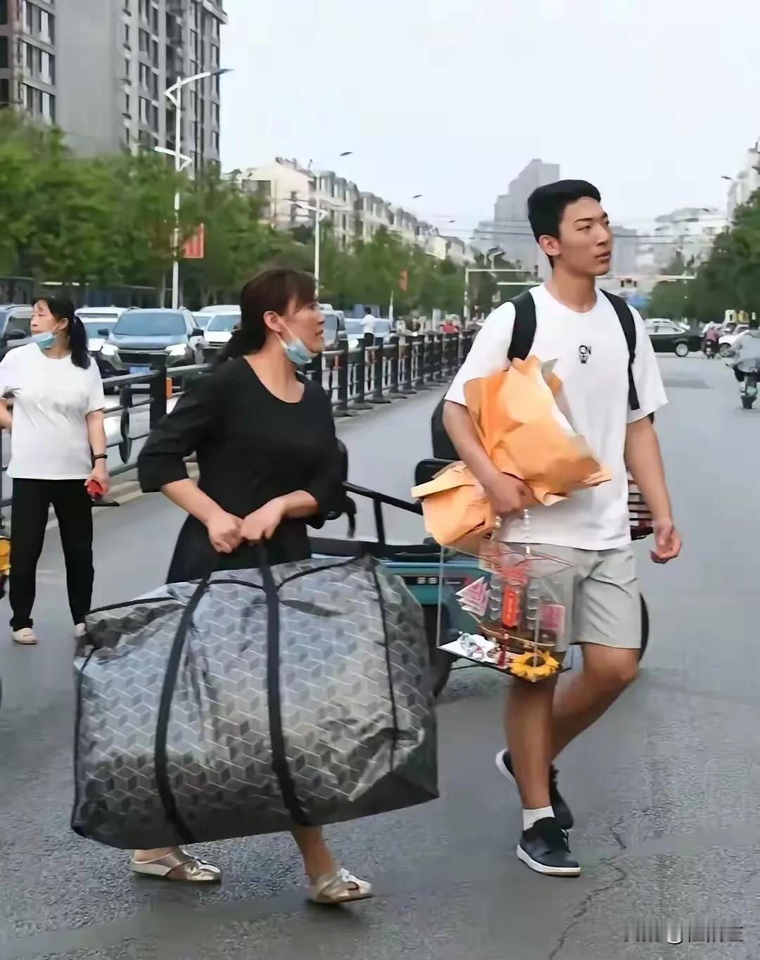 同样是高考结束离校搬运行李，两个孩子，两种表现。
我看到了女孩单薄的肩膀挑起的沉