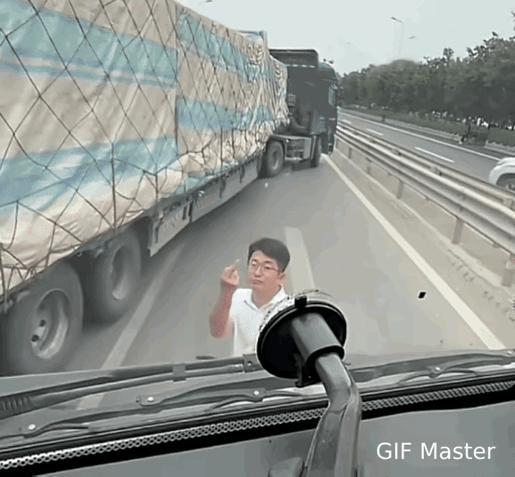 这公路上的惊险一幕真是让人捏把汗！那男子因为行车纠纷就拦停大货车，还不停地竖中指