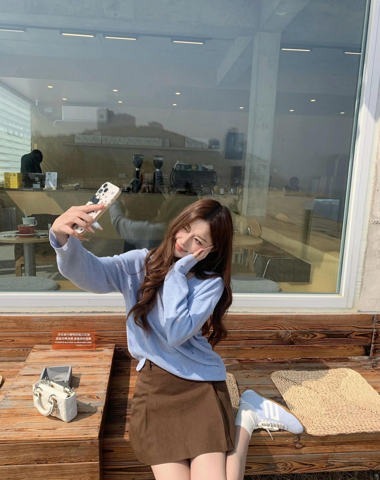 阳光明媚的午后，少女在咖啡馆自拍，享受悠闲时光。