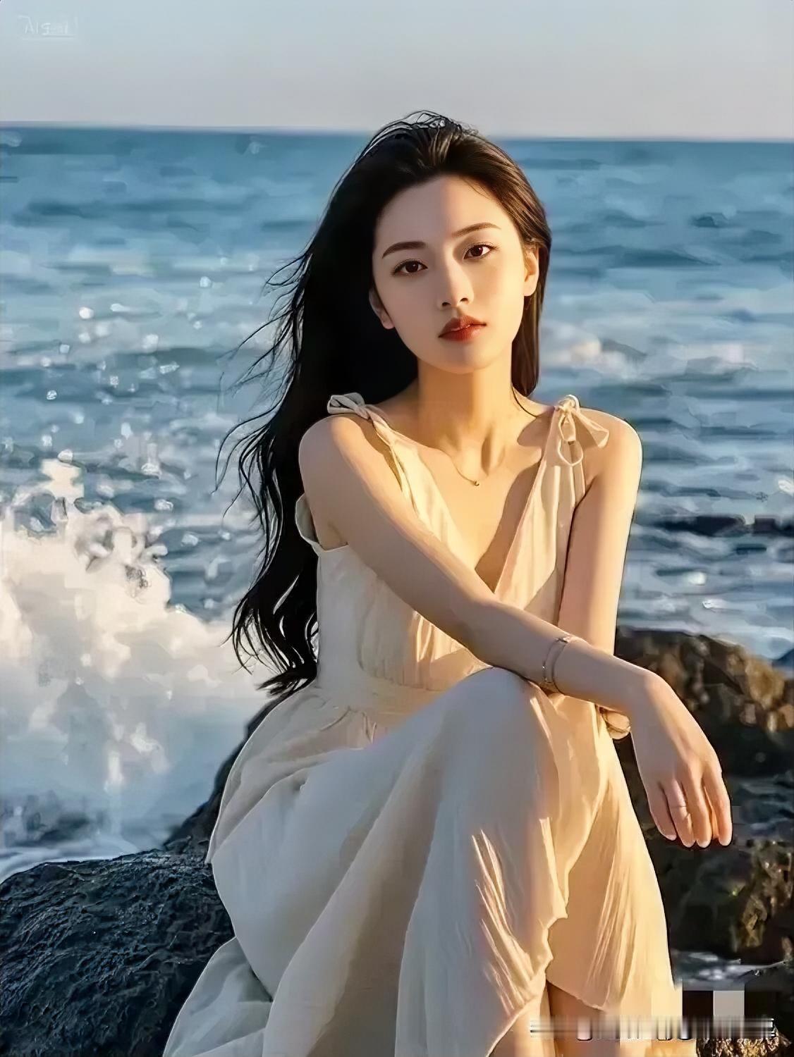 海边轻纱飘逸，少女静坐岩石，海风轻拂发梢。
