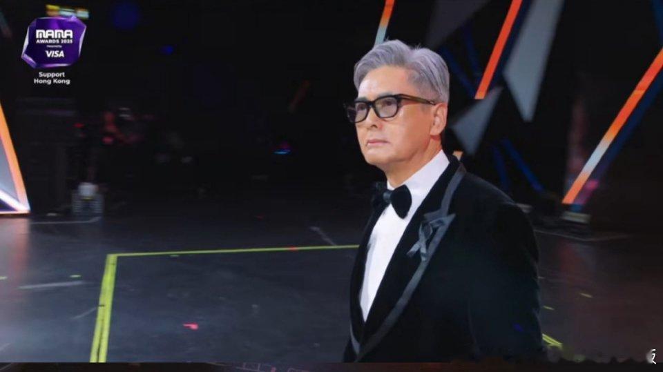当70岁的周润发顶着银发走上2025年MAMA颁奖台，与权志龙重现十年前的牵手拥