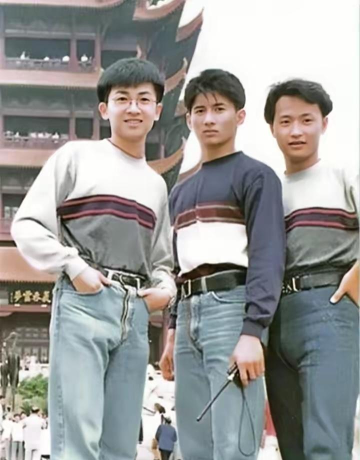 三个年轻人穿着潮流站在街头。这是1991年拍的一张照片，非常年轻。小虎队是不是成