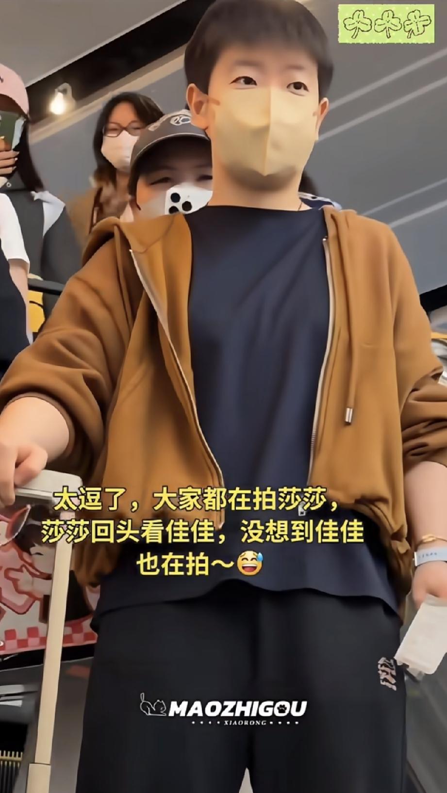 莎莎在电梯上，被一群举着手机的人，直接怼到跟前拍照。戴着口罩的莎莎，看看前面的人