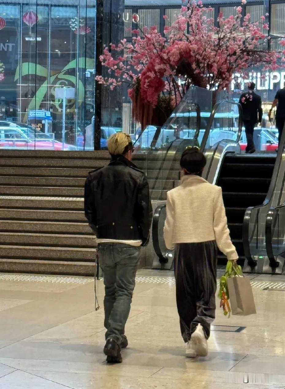 原来不老是有基因遗传的。
谢霆锋陪妈妈狄波拉逛街，谢霆锋染着一头黄发，黑色外套配