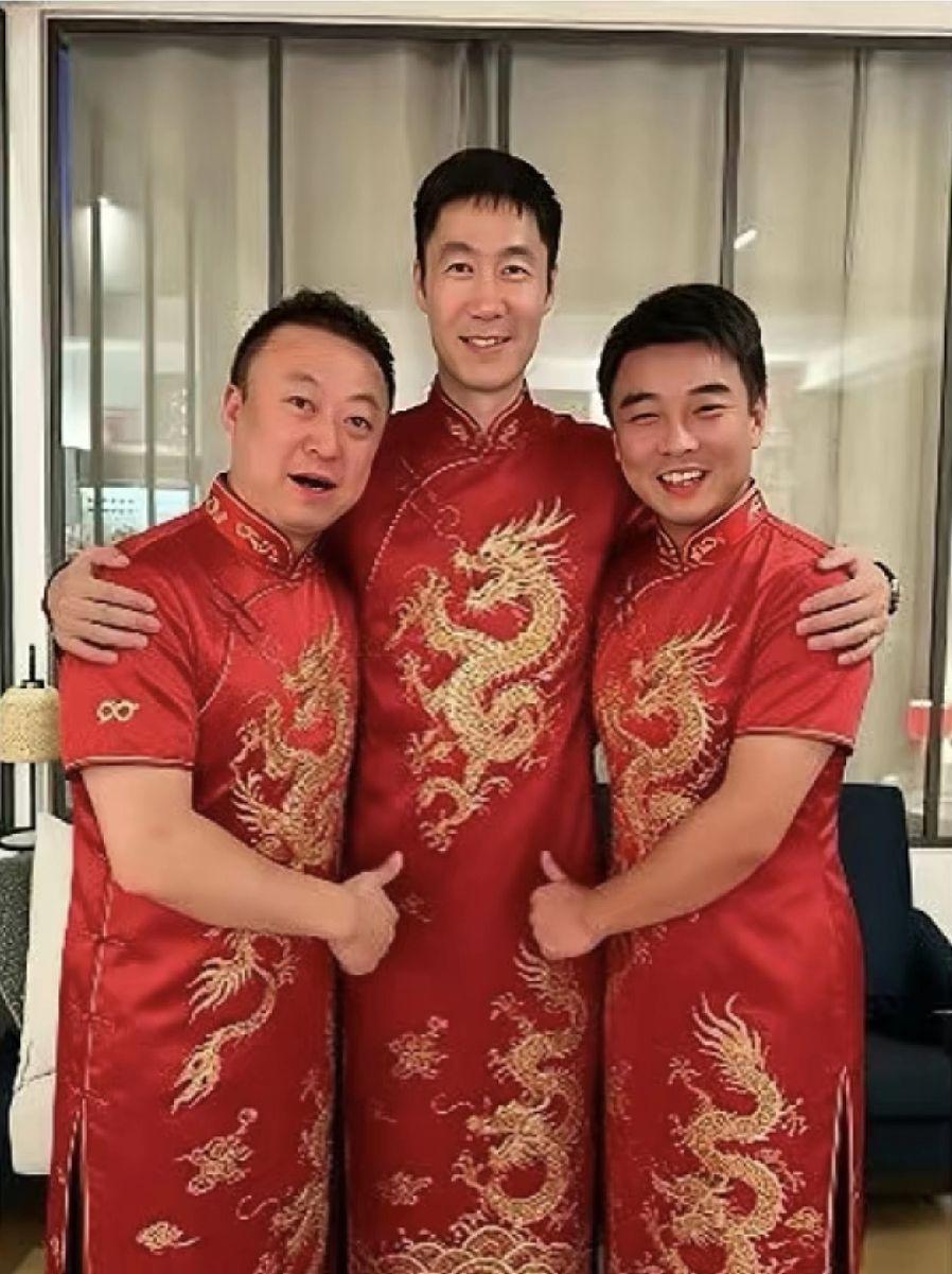 王励勤带着男女队总教练，仨人一块儿穿了红色龙纹旗袍，还集体竖起大拇指比赞。
你平