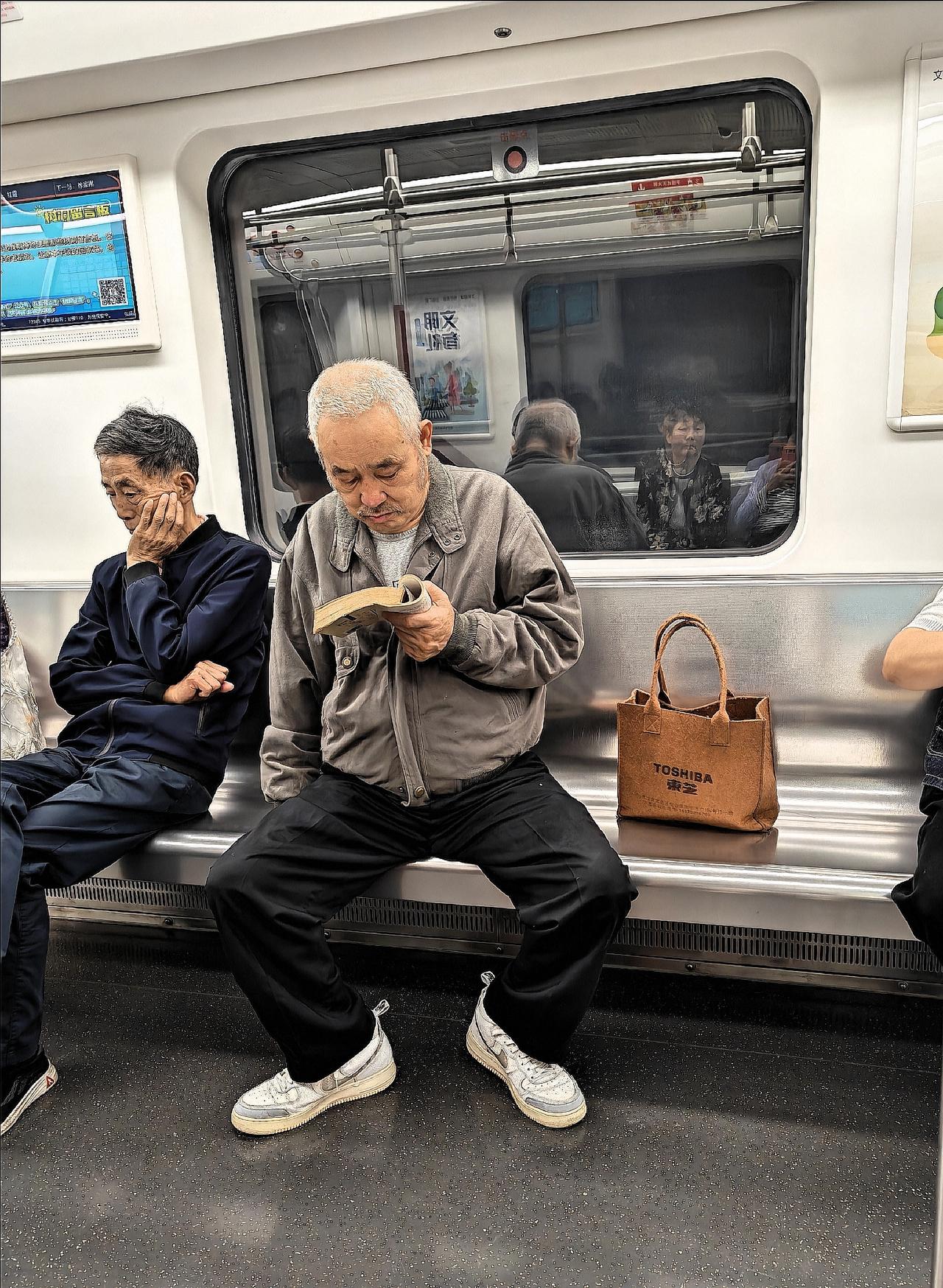 偶遇地铁上的读书人，一个是老年人，读的是纸质书；一个是年轻人，读的是平板上的电子