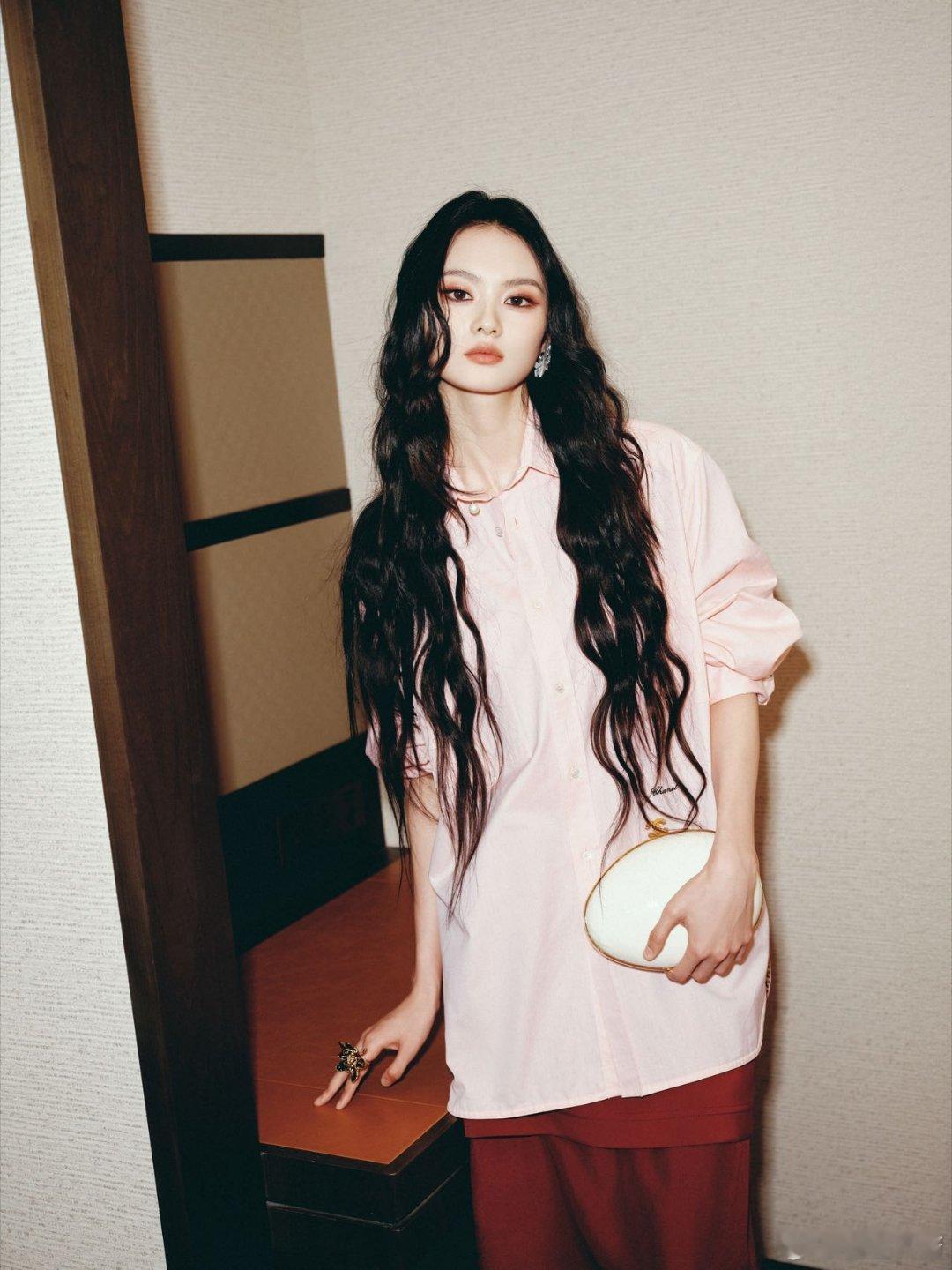 柔粉衬衫漫过腰线，红裙似火燎原，步履间藏着春日与烈焰的密语。圆形手包盛着星光，长