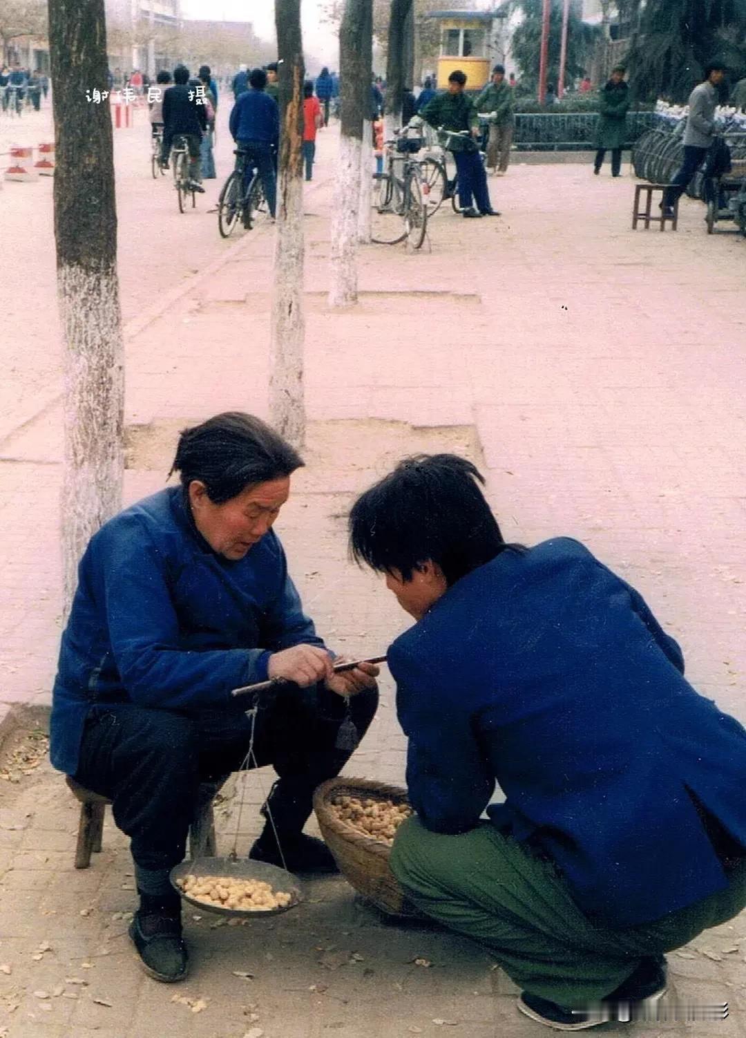 1988年12月7日。陕西户县城南。卖花生的大妈和她的顾客。