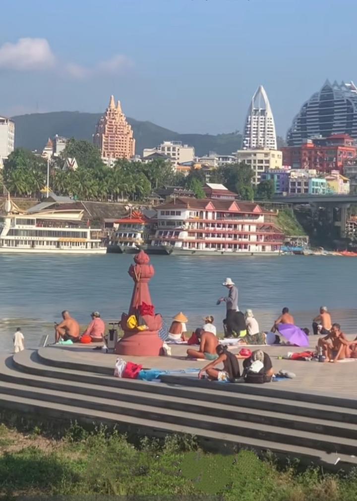 西双版纳澜沧江边的观礼台上，有不少赤裸上身、穿着大裤衩晒太阳的大爷们，不知道他们