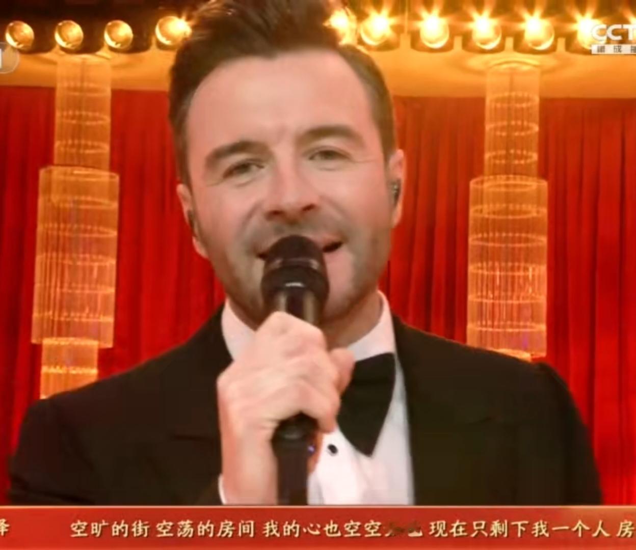 2026总台春晚名场面！外籍歌手身着笔挺西装，在红金交织的华丽舞台上唱响经典。醇