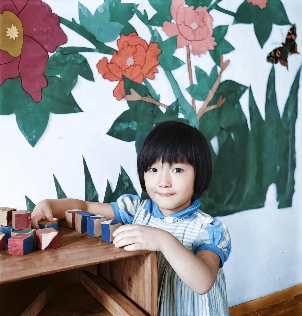 抗战背影下的小女孩。天真无邪的眼睛，可爱的脸蛋，美丽的蓝纹裙子，构成了一幅战争状