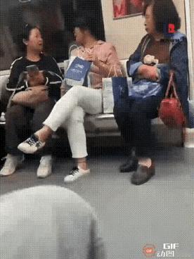 地铁内，一阿姨拿出手机翻看着相册里的照片！这一举动却引起了旁边戴眼镜女子的不满，