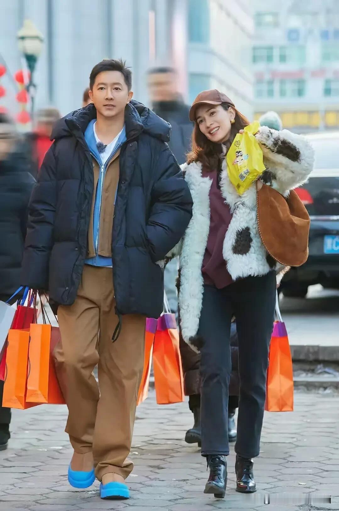 这对明星好接地气，两口子一同逛街买东西大包小包的，男的是演员韩庚，女的是他老婆卢