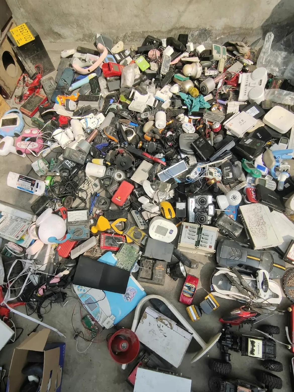 广州鬼市的地上，铺着满满一地旧电子垃圾。
各种老手机、掌机、相机、电线、玩具车，