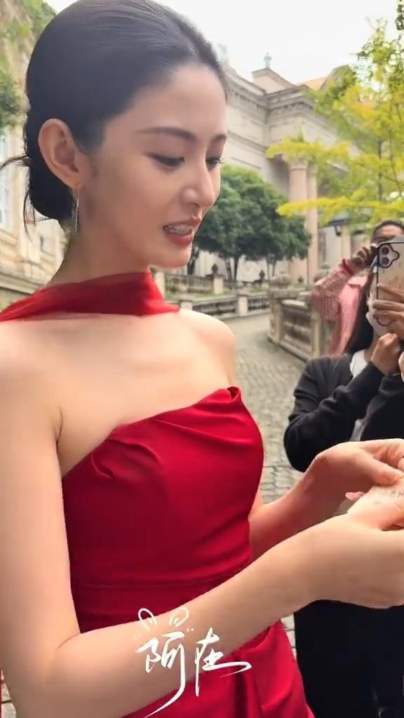 赵晴红裙出妆 谁能拒绝红裙美人赵晴！这套出妆造型，正红缎面长裙搭配颈纱，盘发优雅