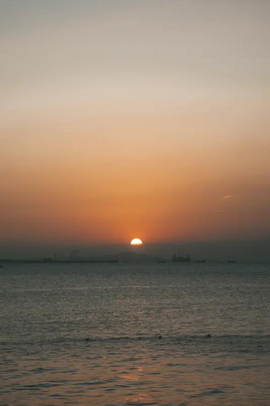 翻相册时，最满意的照片当属那次海边落日。画面里，夕阳悬在海平面上，像个大火球，把
