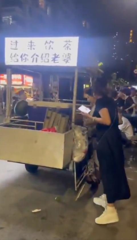 广东湛江发生的一起爆笑街头事件：一位卖茶摊的摊主挂出“过来饮茶，给你介绍老婆”的