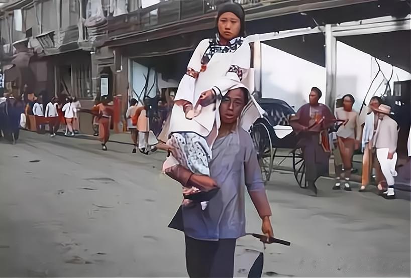 晚清时期，一名龟公扛着妓女出门陪客，照片中这个妓女的年龄还不大，被五大三粗的龟公