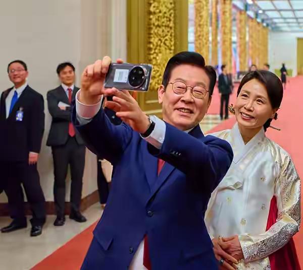 李在明也喜欢自拍，还带上妻子。还好他妻子气质挺好的，他拍任他拍，她自信着呢。