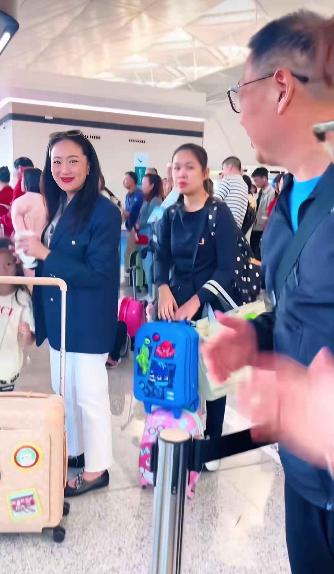 佩通坦携家人在机场现身，褪去总理光环，化身平凡母亲。她身着干练西装，一手牵着女儿