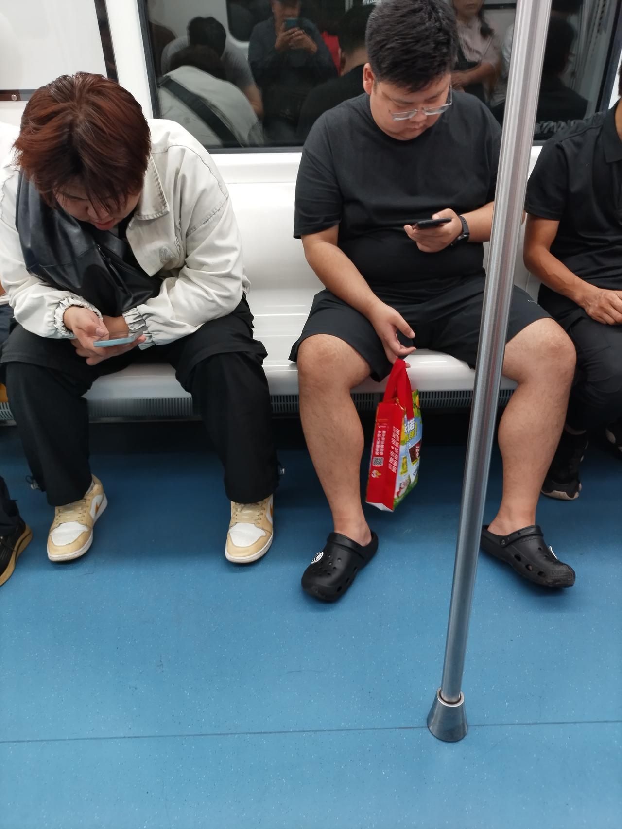地铁对面坐的两个大胖子。

这两个大胖子的坐姿也很特别。

本来能坐三个人的坐，