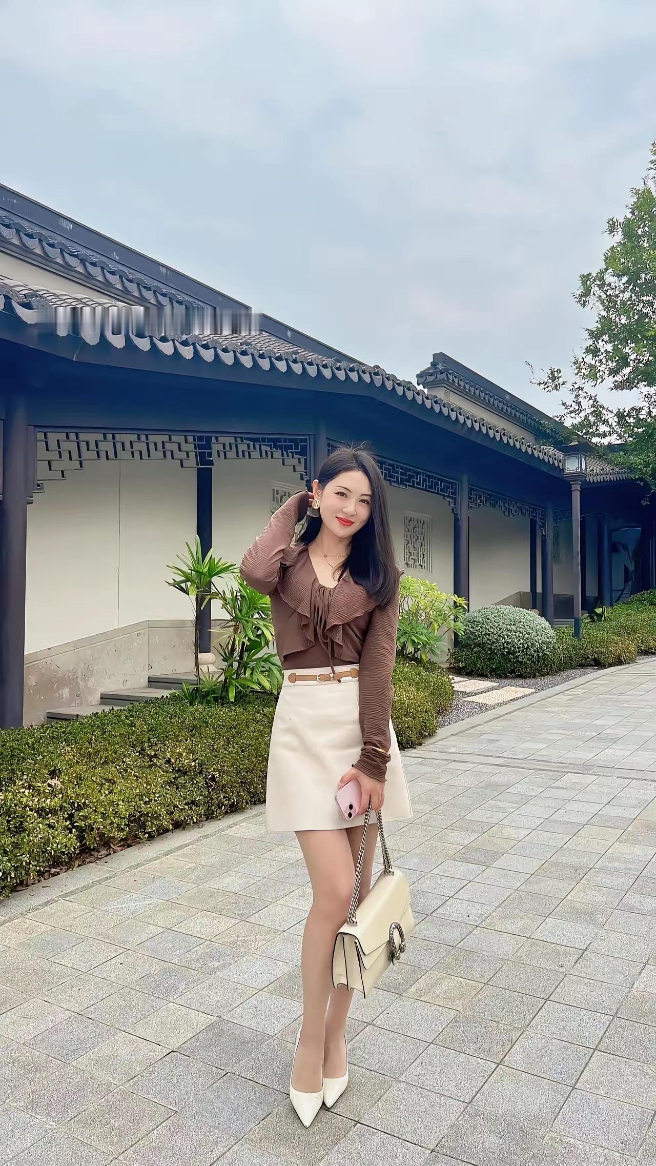 优雅漫步在古风建筑旁，时尚穿搭尽显魅力。