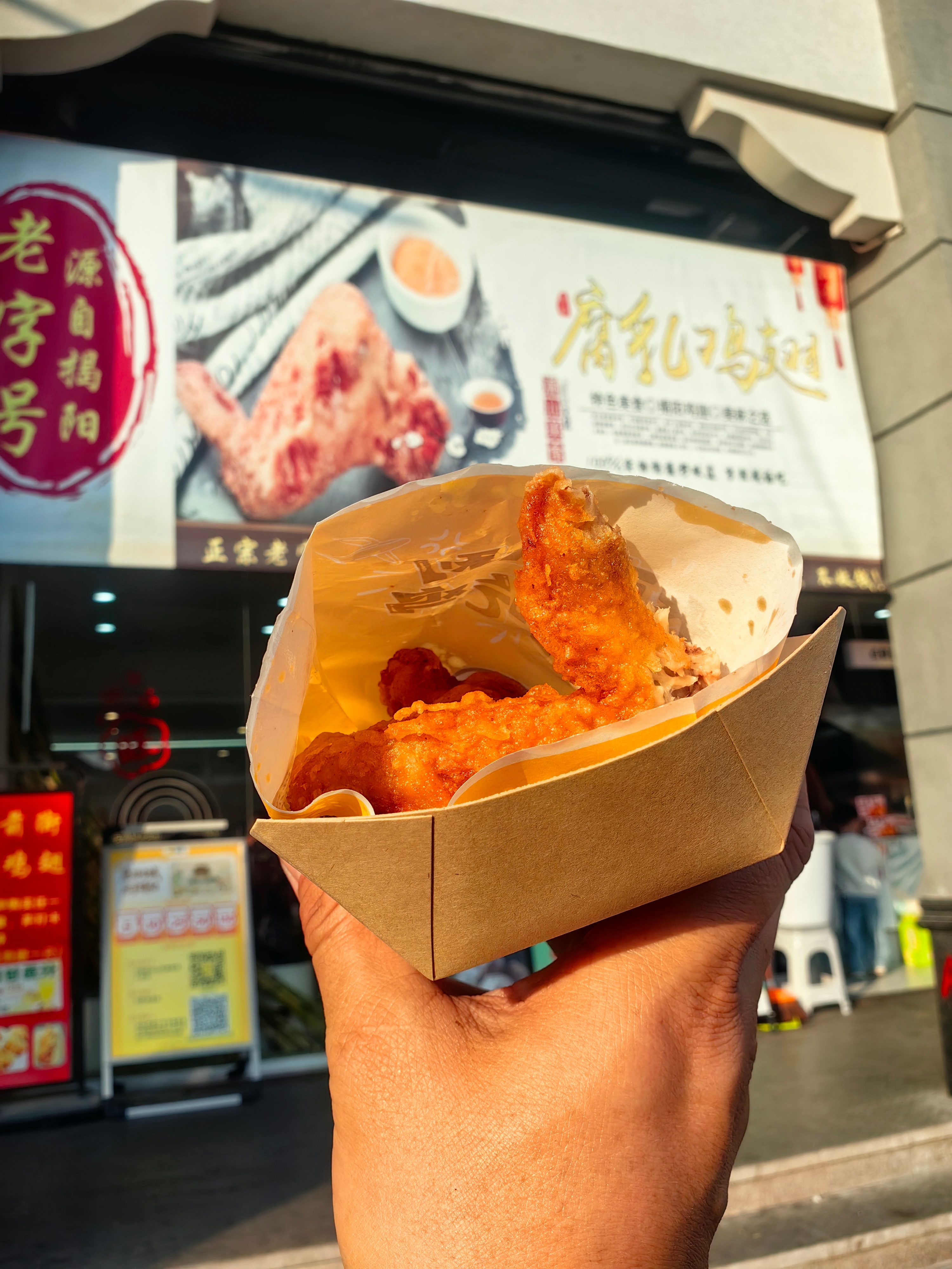 *在路上*腐乳鸡翅...排了长队，新出锅的，咬一口满嘴腐乳香，味道还不错...哈