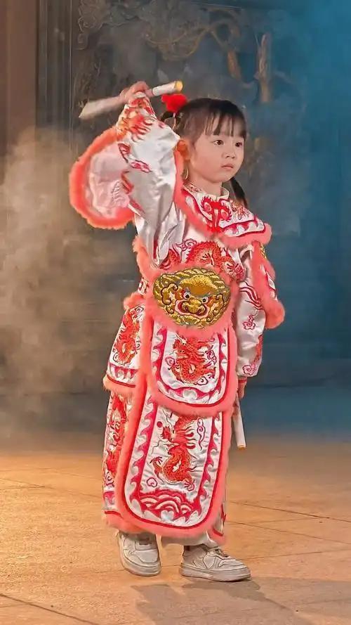 香港街头，6岁女孩庄恩琪身着粉色战袍，在英歌舞表演中稳居C位炸场！她手持迷你英歌